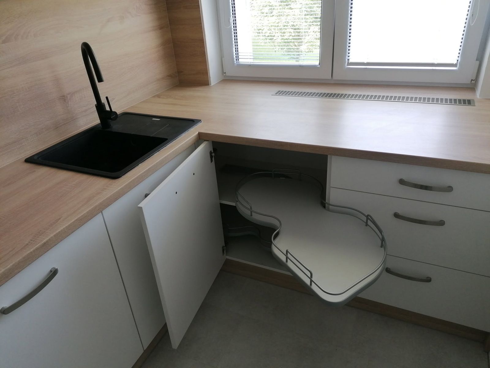 Bílá kuchyň s dřevěným obkladem v podkrovní místnosti