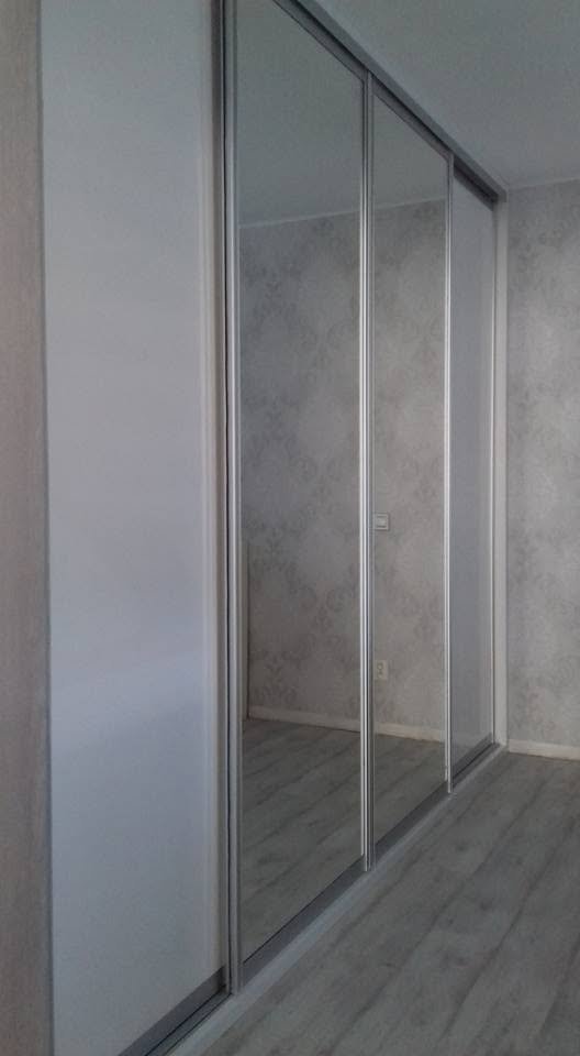 Bílá vestavěná skříň se zrcadlovými posuvnými dveřmi